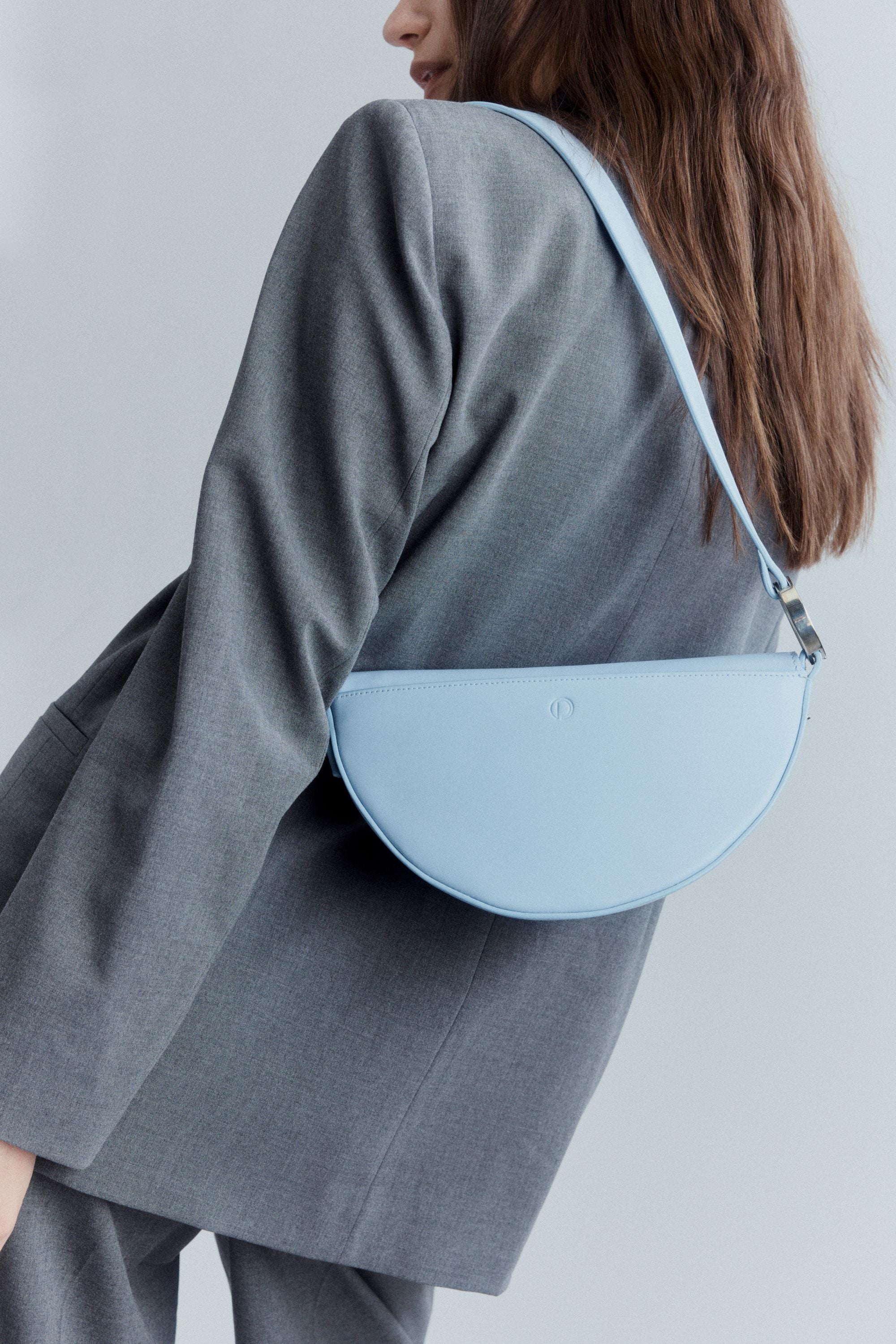 Celeste handbag in sky blue Italian calfskin leather with sculptural silhouette and signature logo hardware