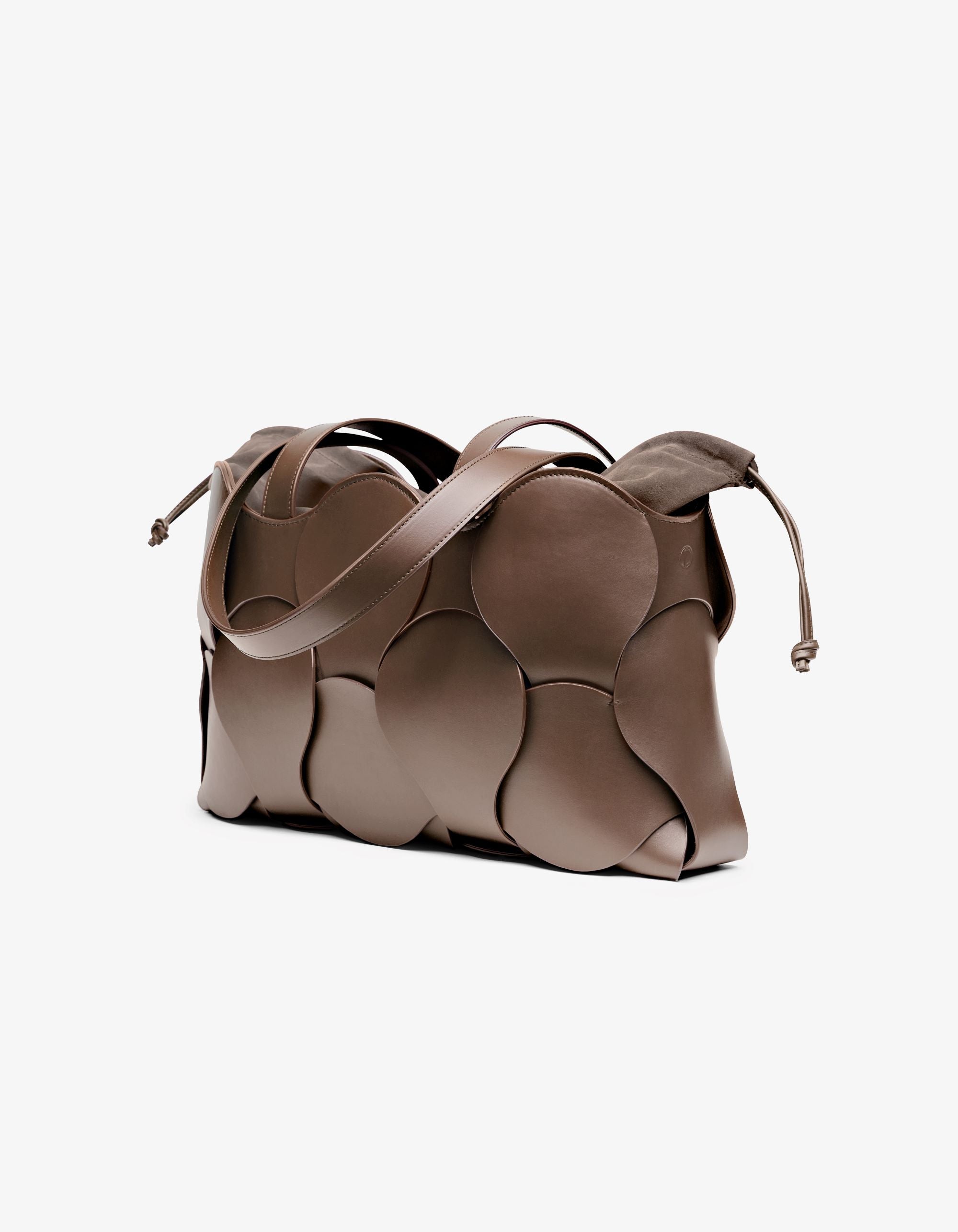 Elegant taupe Gigi tote with woven circular motif, removable suede drawstring pouch, suede-lined interior, and NYC-made quality