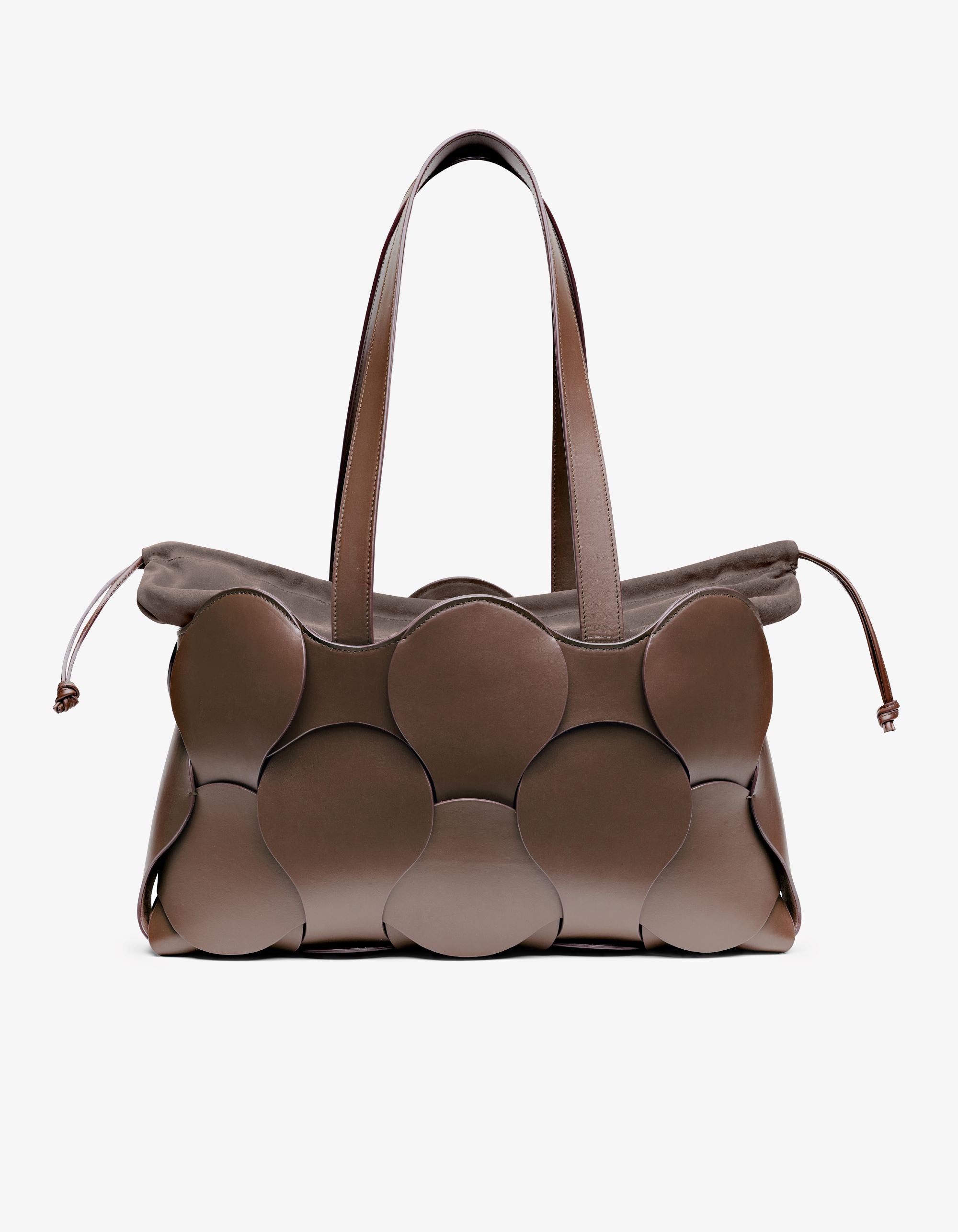 A brown Gigi Tote handbag made from Italian calfskin leather with a sculptural form and a removable suede drawstring liner.