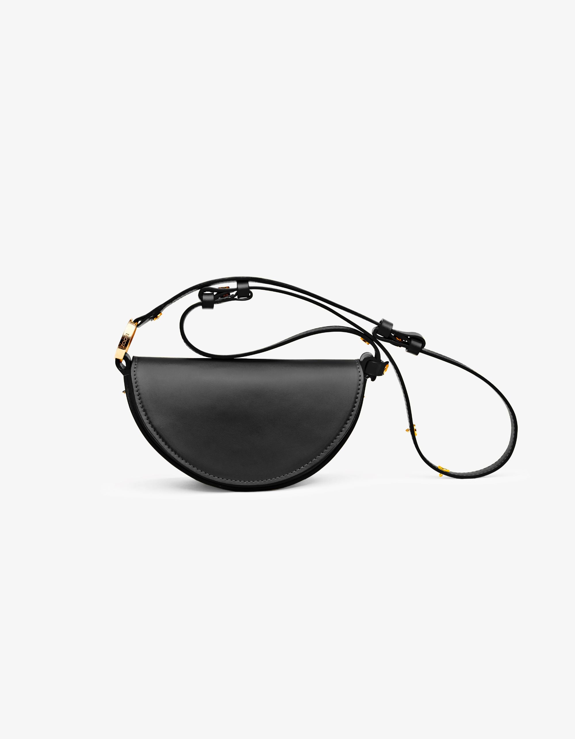 A black Mini Céleste handbag with a half-moon shape, handcrafted from Italian calfskin leather, with an adjustable strap.