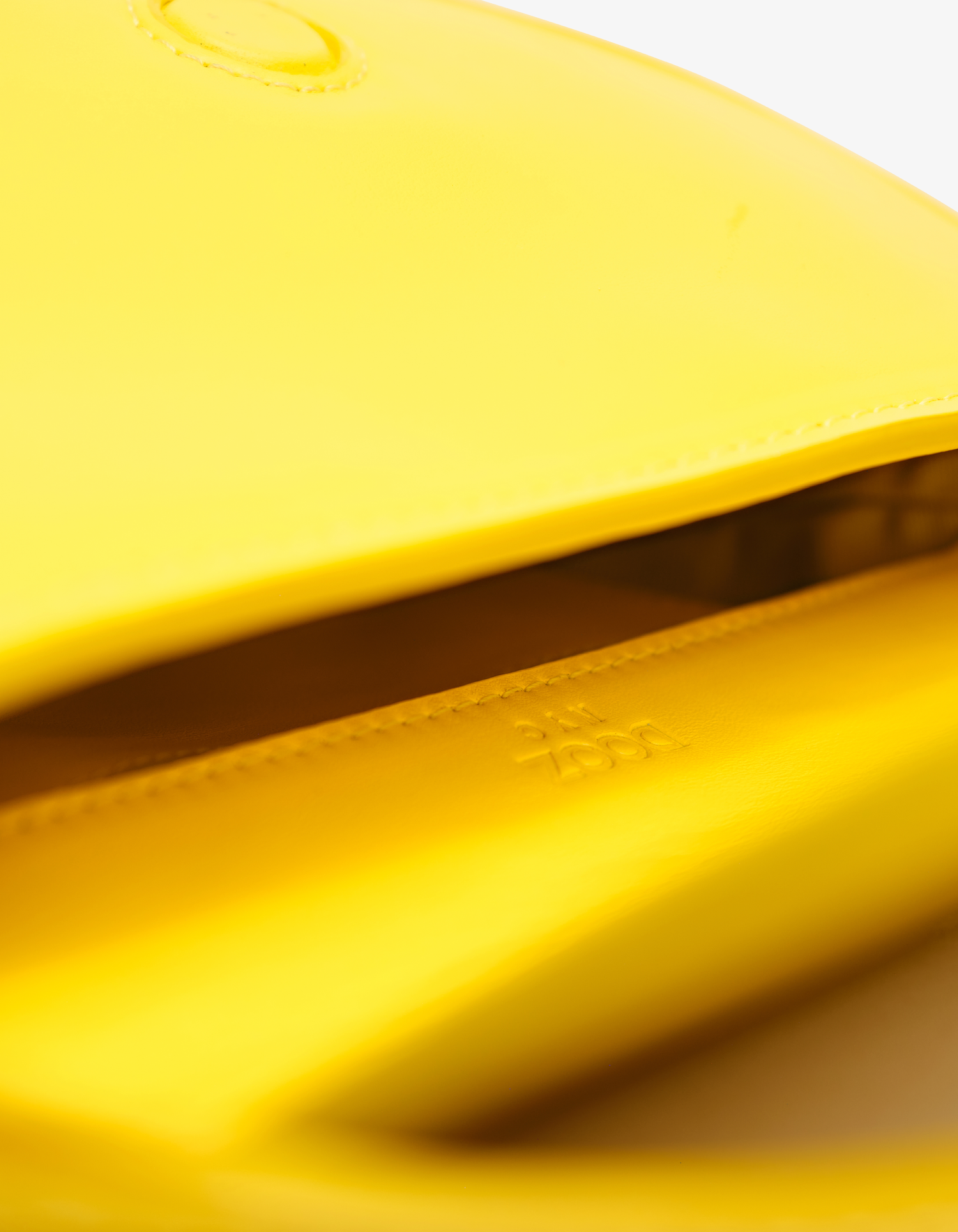 Dooz Mini Celeste in canary yellow leather, sculptural form, signature logo hardware, and convertible strap