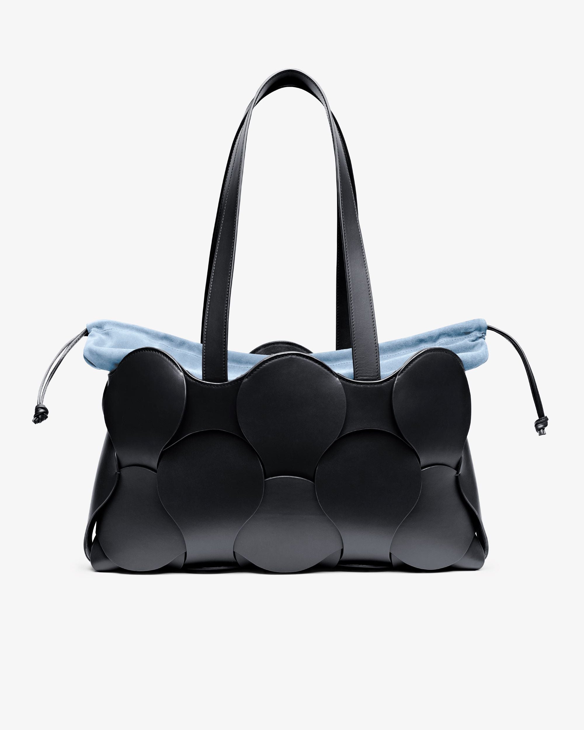 A black Gigi Tote handbag made from Italian calfskin leather, featuring a spacious design with a blue drawstring detail.