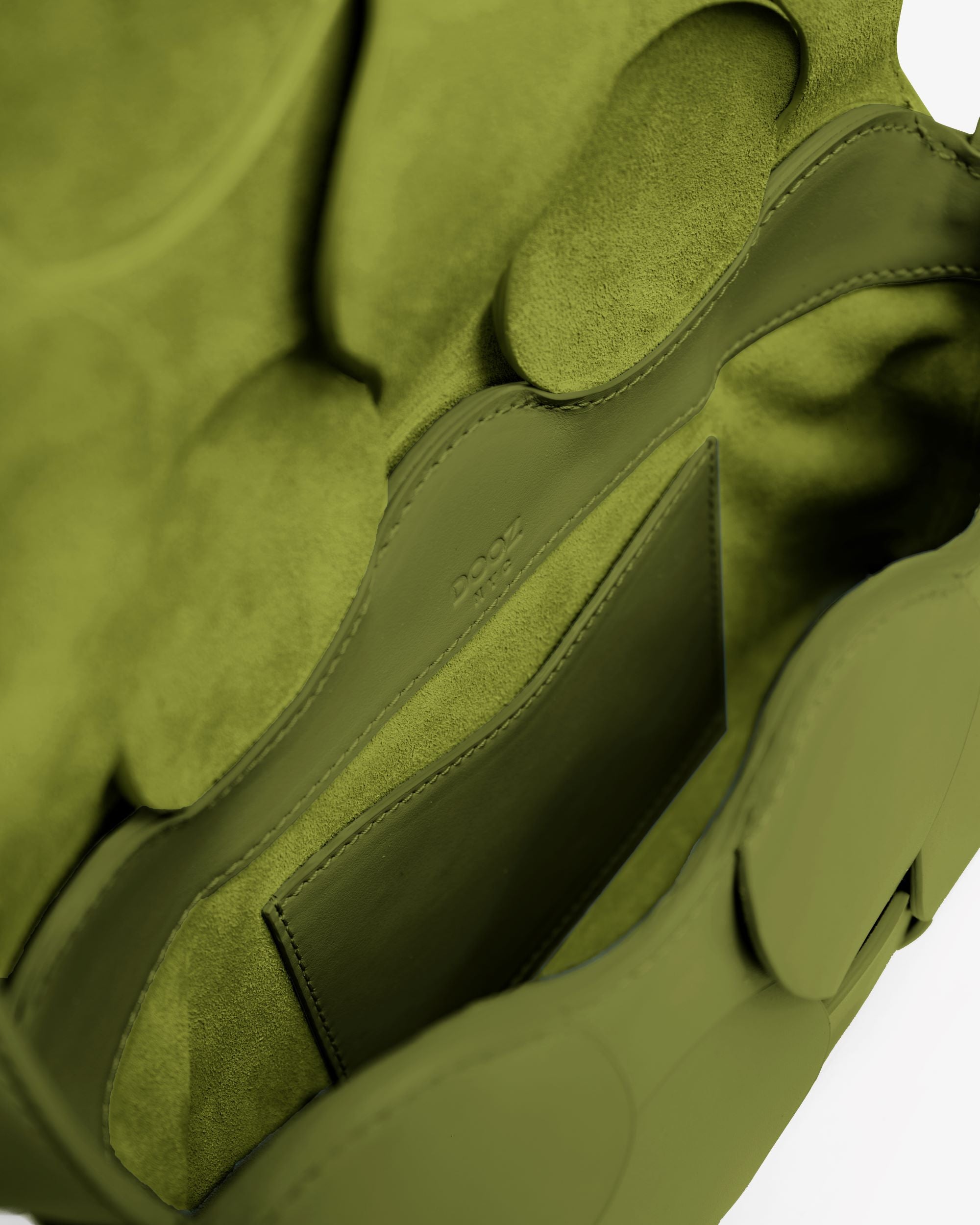 Moss Gigi bag with NYC artisan craftsmanship, sculptural silhouette, magnetic flap, woven circular leather motif, and shoulder/crossbody functionality