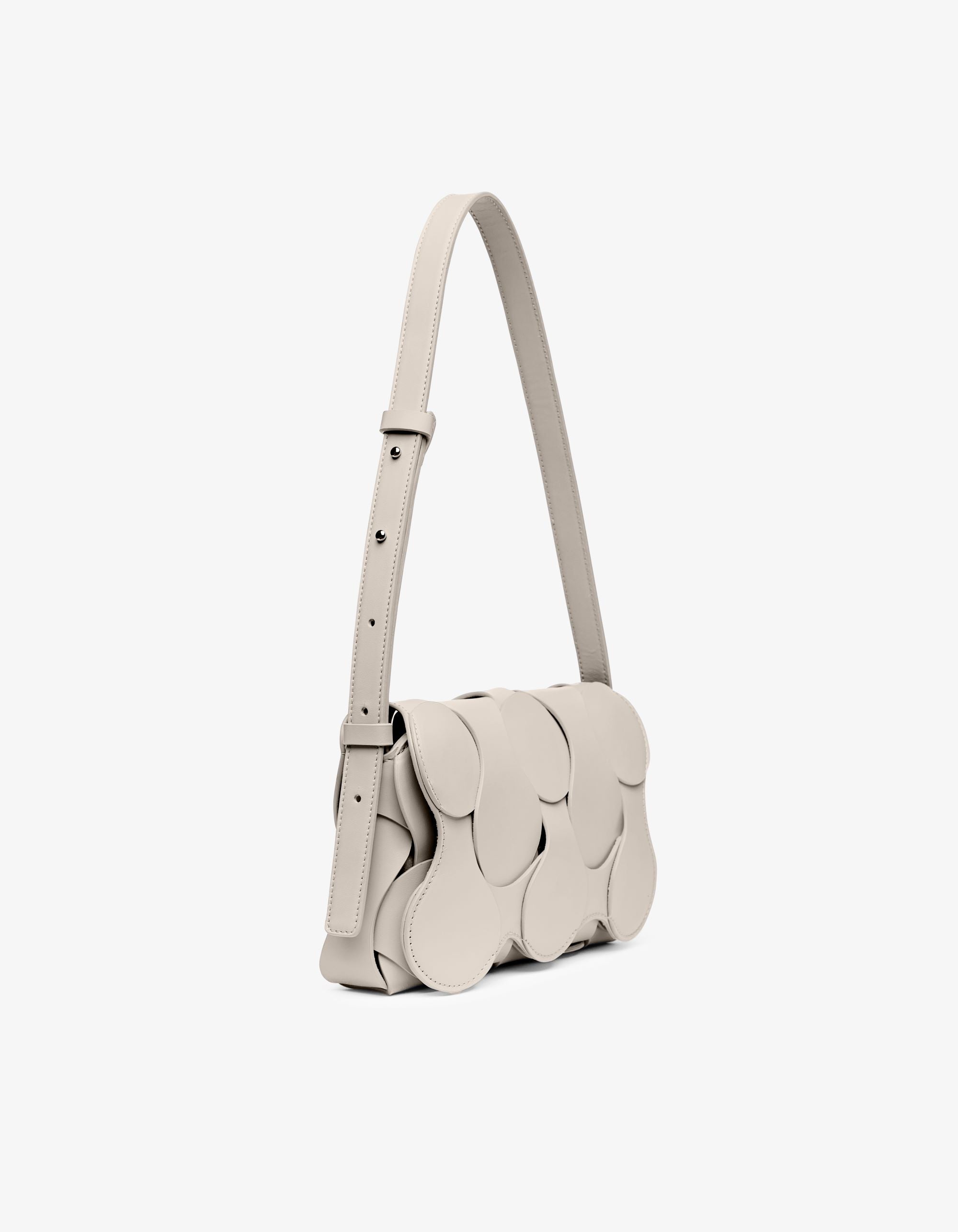 Gigi bag in parchment Italian calfskin leather, handmade in NYC, featuring woven circular leather motif, magnetic flap, and shoulder/crossbody strap