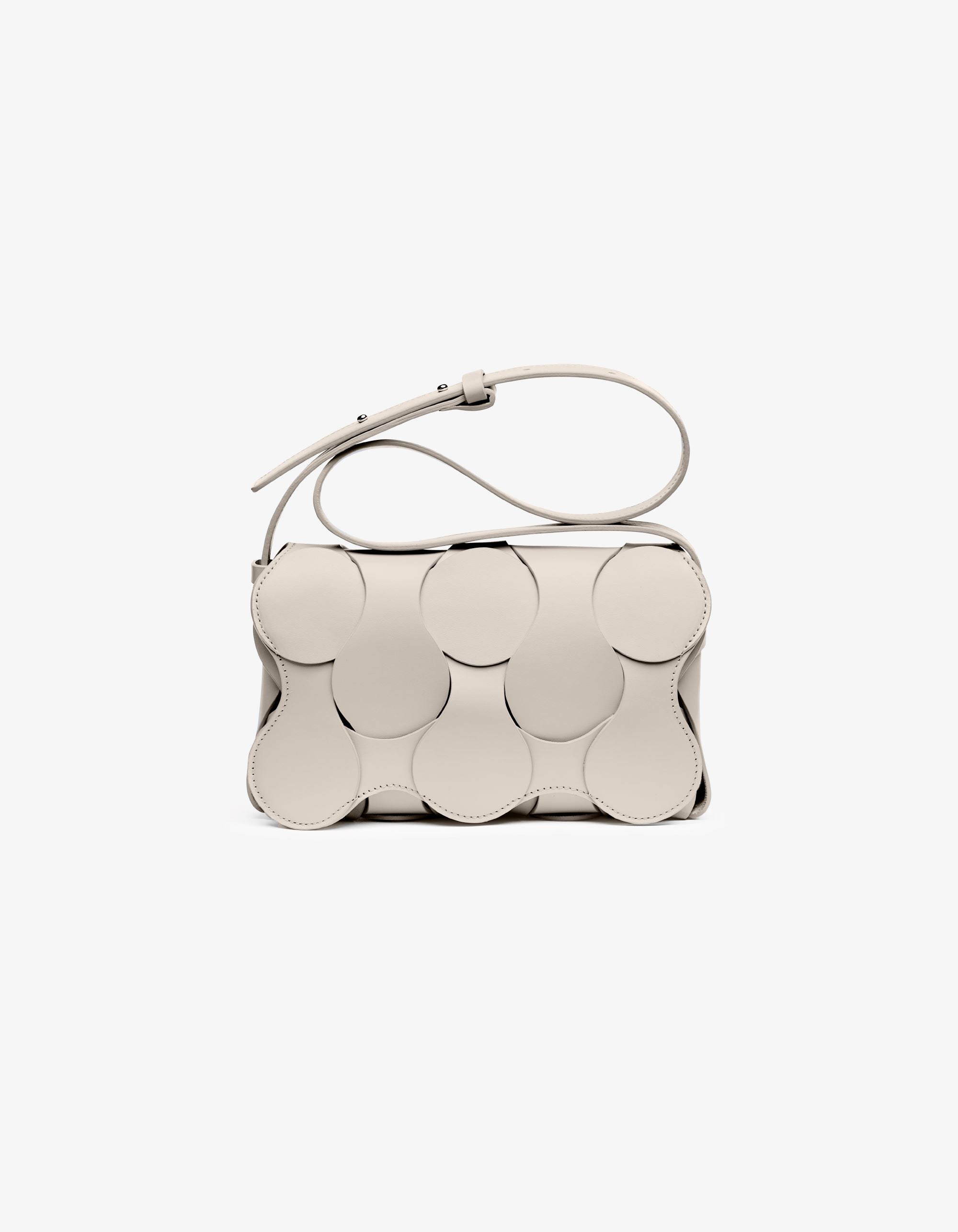 Dooz Gigi bag in parchment leather, hand-stitched, magnetic flap, circular woven detail, and versatile shoulder/crossbody strap