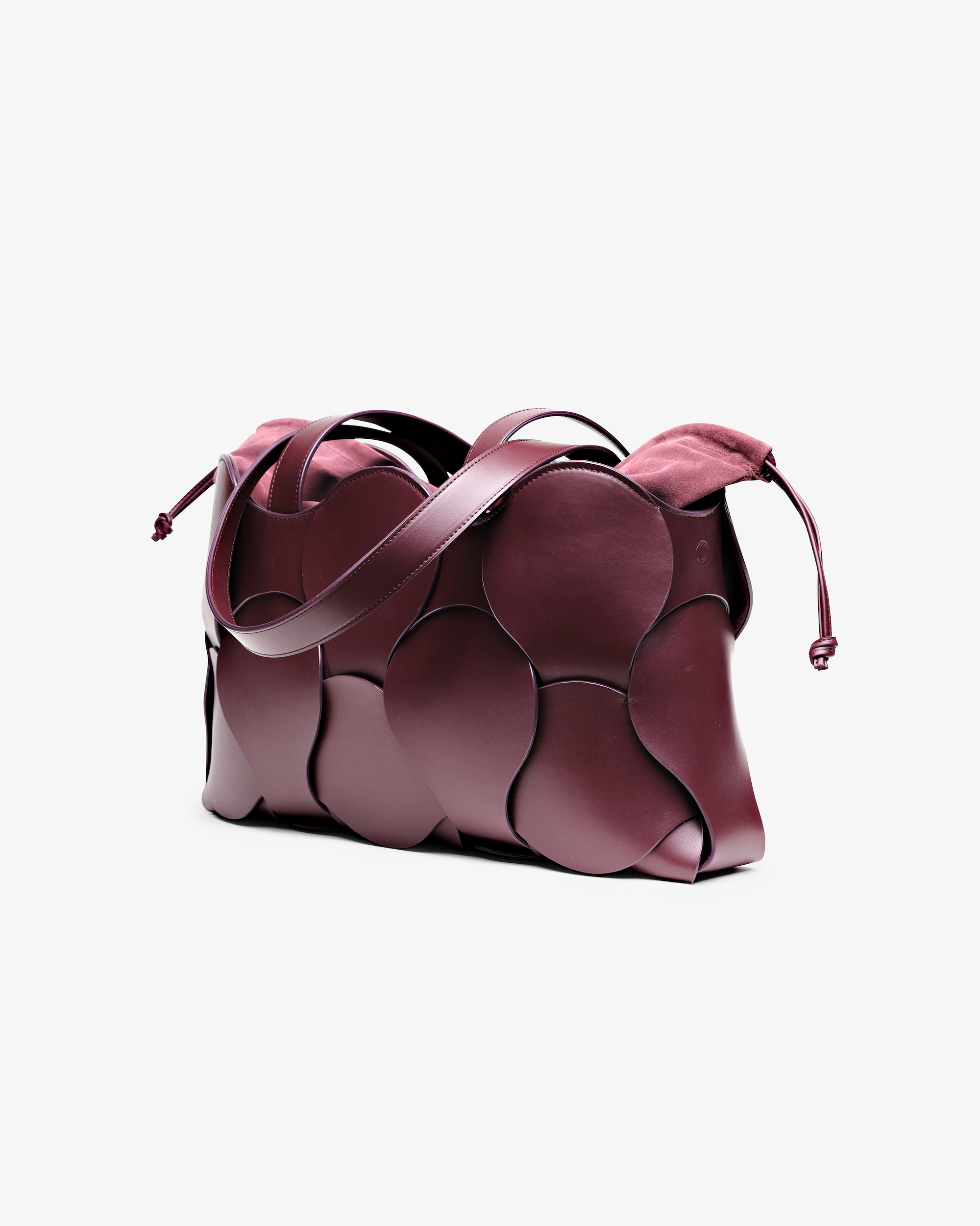 Elegant bordeaux Gigi tote with woven circular motif, removable suede pouch, suede-lined interior, and NYC-made quality