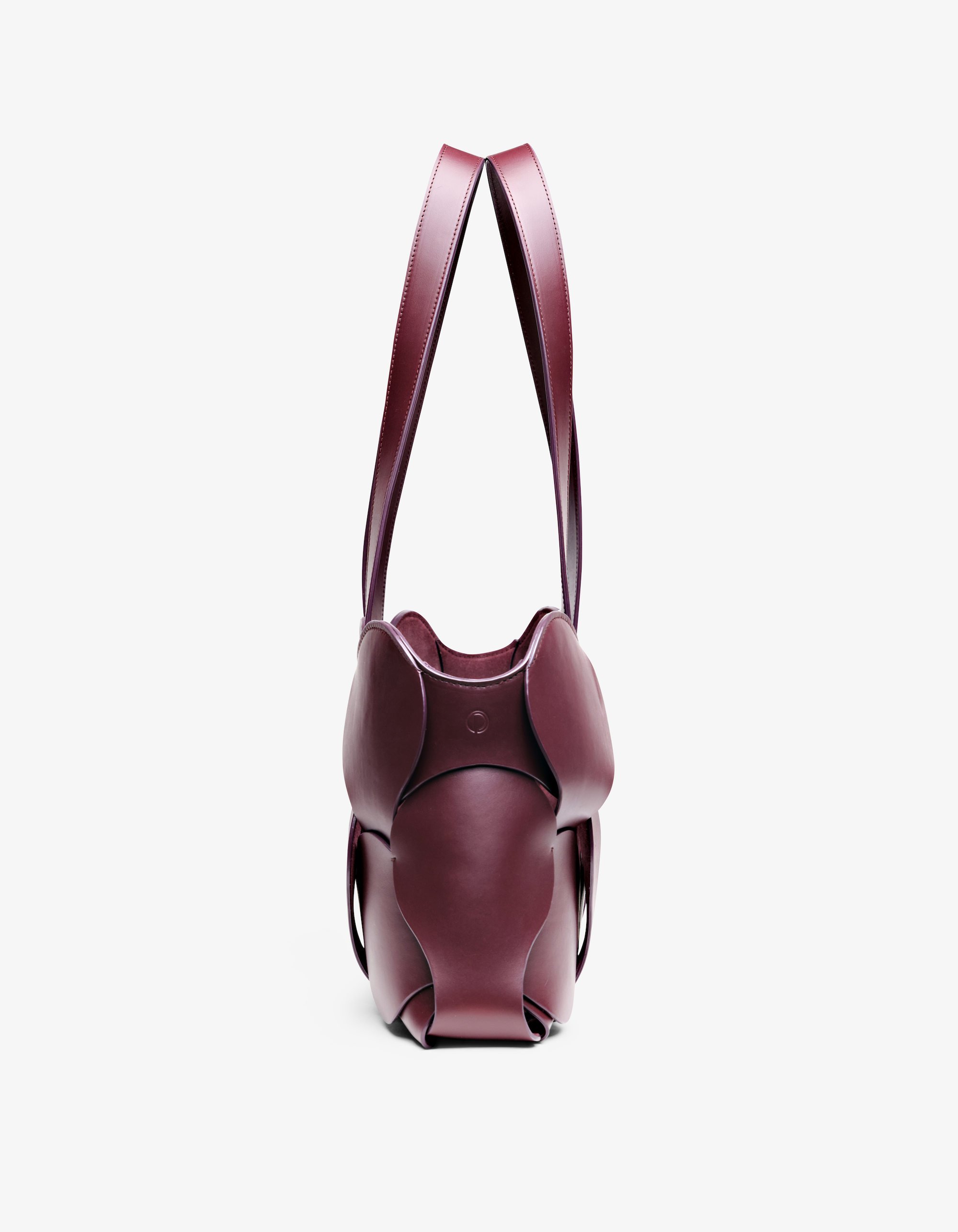 Oxblood Gigi tote featuring NYC craftsmanship, sculptural Italian leather, woven circular detail, and removable suede liner