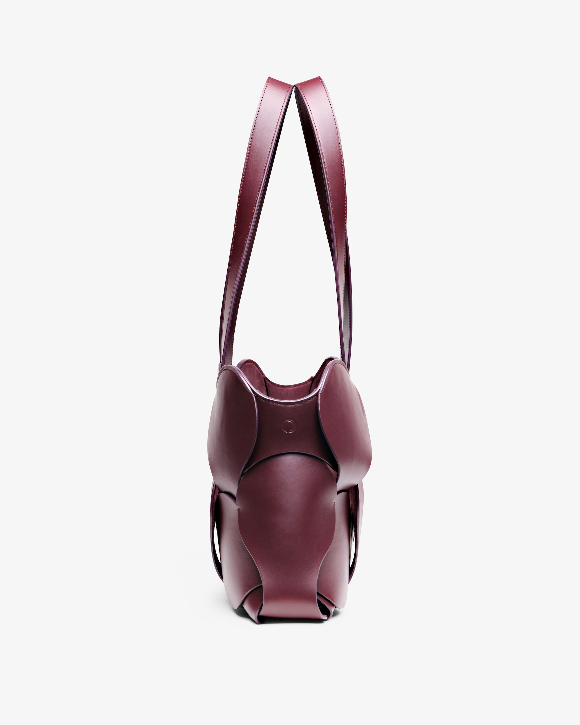 Oxblood Gigi tote featuring NYC craftsmanship, sculptural Italian leather, woven circular detail, and removable suede liner
