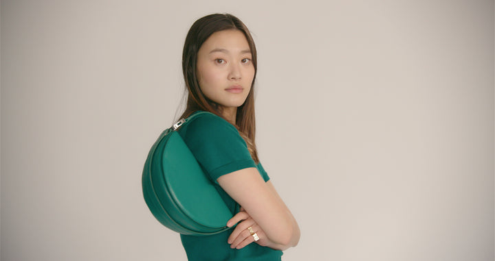 Taurus Dooz muse Gia Seo wears the Taurus green knit tee and Taurus green leather crescent handbag