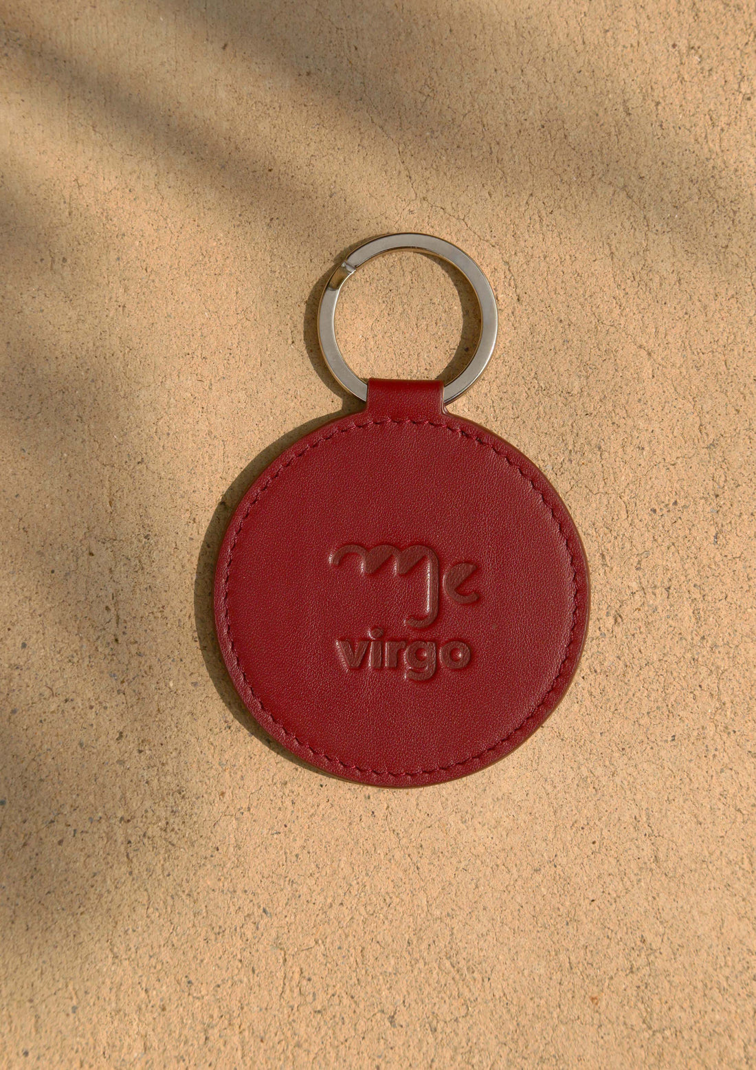 Dooz Virgo burgundy leather keychain with embossed zodiac glyph and silver keyring stillife