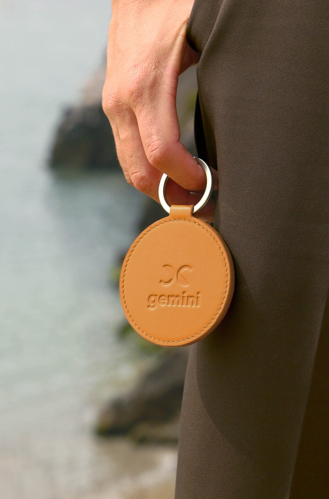 Dooz Gemini golden embossed leather keychain with glyph on model