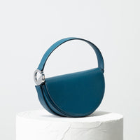 Dooz Cancer teal leather half moon handbag with short strap and front magnetic flap color power